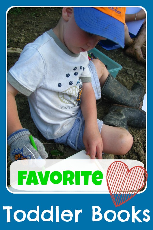 Toddler sit in dirt and writes in a nature journal