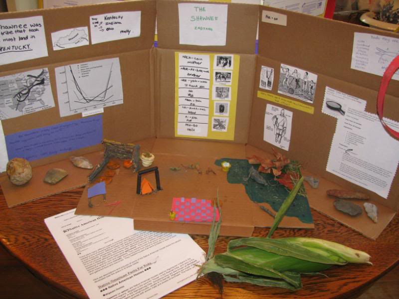 Presentation board about Shawnee Indians with a model of an Indian home in the woods, and an ear of corn.
