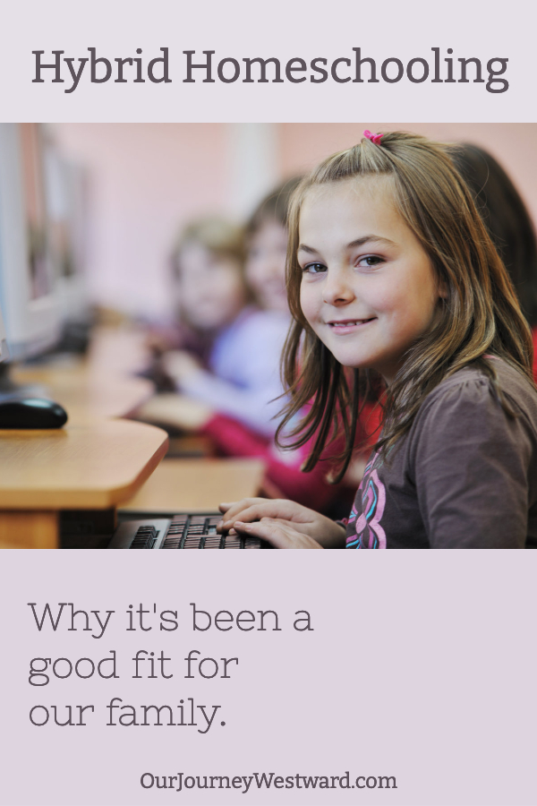 Girl in brown shirt smiles at the camera with hands on a keyboard. This image is for a post about hybrid homeschooling.