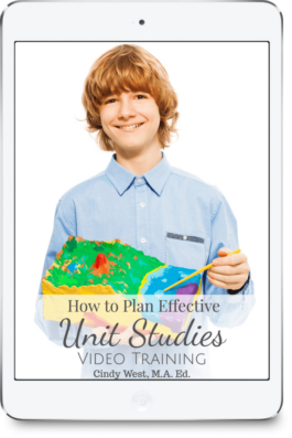 Blonde boy in blue button down holds a clay model of a volcano that he has painted in various colors, and holds a yellow paintbrush in the other hand. Used as the cover for a masterclass about unit studies.