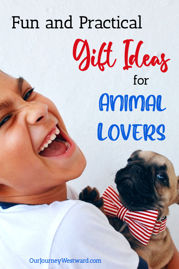 Boy grinning and holding a dog with a red and white striped bowtie. Promoting a blog post about gifts for animal lovers.