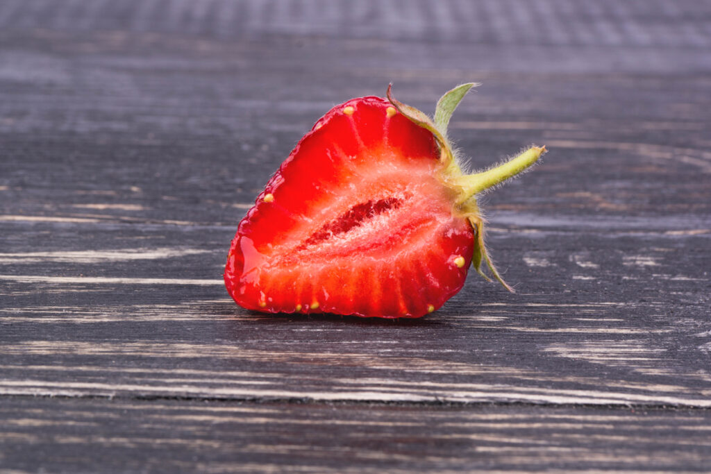 strawberry cut in half on wood table